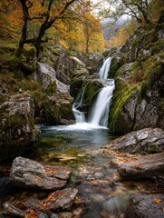 Naklejka premium Serene waterfall cascading through autumn forest mountainous region nature photography tranquil atmosphere landscape view