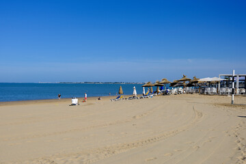 Chatelaillon Plage beach with straw parasols and deckchairs . Châtelaillon-Plage is a commune in the Charente-Maritime department