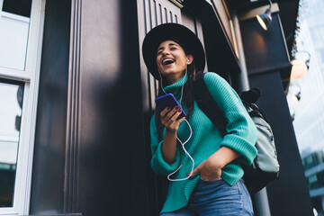 Smiling brunette woman, 30, interacts with a tablet, engaging with technology in a relaxed posture,...