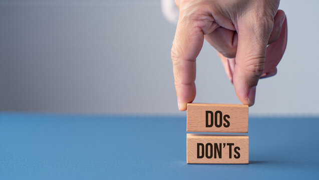A hand is placing wooden blocks with the words dos and donts, representing rules and guidelines