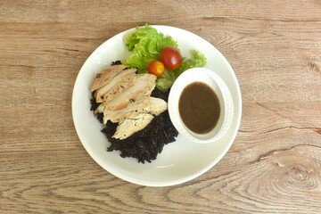 grilled slice chicken black pepper on riceberry with tomato and lettuce on plate dipping Thai spicy tamarind sauce