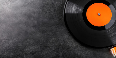 Obraz premium Vinyl record with an orange label lies on a textured surface. Concept: retro music, nostalgia, vintage sound