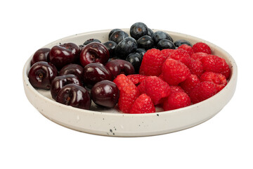 The High resolution fruit photo of mixed fruits including cherries, raspberries and blueberries arranged on a plate, taken with split focus technique.