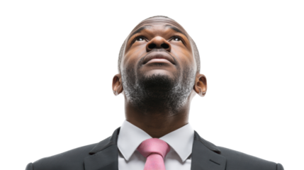 Suit-clad man looking upwards, expressing hope and ambition, against a white isolated background.