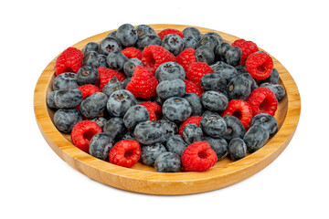 The High resolution fruit photo of mixed fruits including cherries, raspberries and blueberries arranged on a plate, taken with split focus technique.