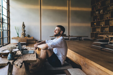 Freelancer enjoying moment of relaxation with laptop nearby, reflecting peaceful satisfaction from...