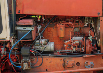 Exposed tractor engine showing battery, fuel system and rusted components