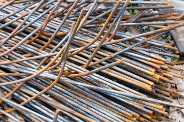 Rusting metal rebar rods piled on construction site outdoors