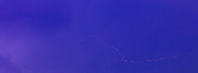 Thick, dark storm clouds swirl and stretch across the sky in a dramatic display, creating a moody and atmospheric scene with copy space.