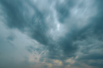 Thick, dark storm clouds swirl and stretch across the sky in a dramatic display, creating a moody and atmospheric scene with copy space.