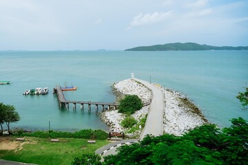 Small lighthouse on the shore of the sea at Khao Laem Ya, Rayong, Thailand. Little wooden white life guard tower. Summer travel vacation and holiday concept. Seascape Bridge and Pier.