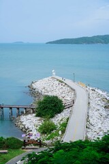 Small lighthouse on the shore of the sea at Khao Laem Ya, Rayong, Thailand. Little wooden white life guard tower. Summer travel vacation and holiday concept. Seascape Bridge and Pier.