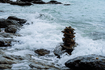 Pebble heap on a beach serene blue sea background zen balanced stones. Close up of rock stack beach in Thailand. Balanced stones on a pebble beach. Nature background concept of balanced rock tower