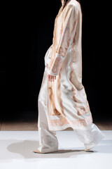 Fashion woman wearing long white outfit pants and silk cardigan, fancy cloth on black background