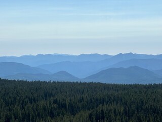 Breathtaking view of layered mountain ranges under a clear blue sky in the early morning