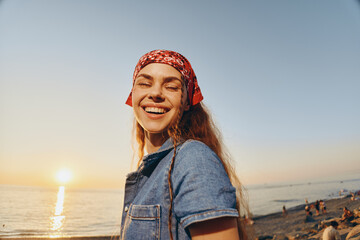 lifestyle woman wearing modern boho-western denim street style smiling at sunset, enjoying relaxed...