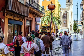 People in costumes march during Corpus Christi celebrations in Valencia, Spain against a street...