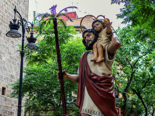 Statue of Saint Christopher on Corpus Christi Day in Valencia against a backdrop of green trees