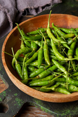 Fresh Green Bird’s Eye Chilies on Wooden Background for Asian Cuisine and Natural Cooking Ingredients