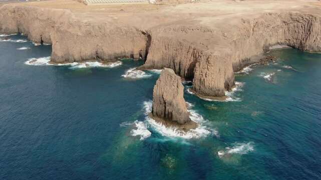 Turquoise water splashing on Risco Partido volcanic rocks in Gran Canaria