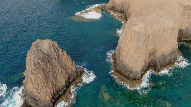 Aerial view of Risco Partido breathtaking rocky formations and crystal clear ocean in Gran Canaria, Canary Islands, Spain