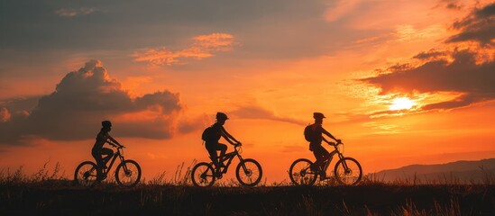 Fototapeta premium Silhouettes of three cyclists at sunset