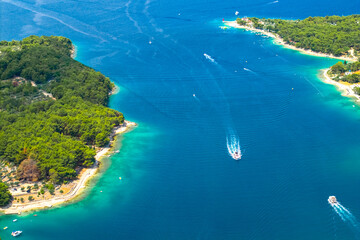 Aerial panorama of boats sailing around green coastline, Cres island. Travel to Croatia 