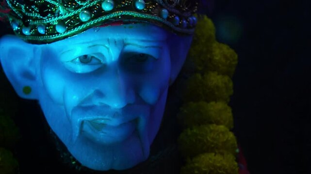 Sai Baba Idol in Blue Lighting with Marigold Garland