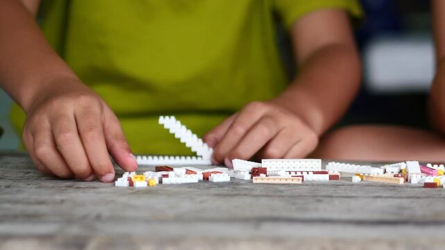 Children hands play with colorful lego blocks 