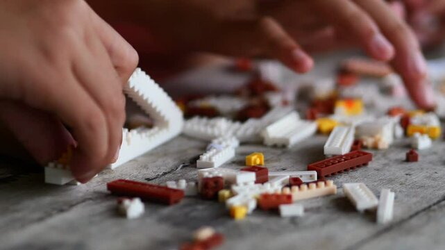 Children hands play with colorful lego blocks 