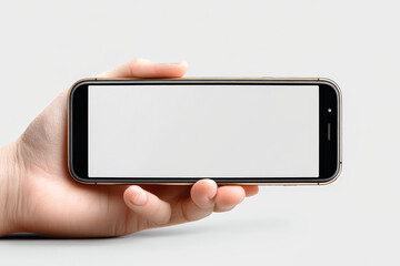 Person is holding a phone with a white screen. The phone is in a hand and the person is looking at the camera
