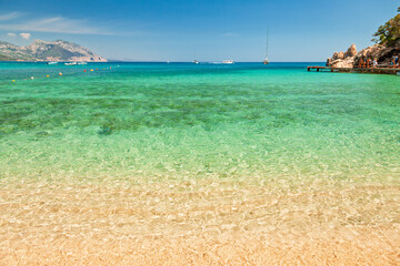 Crystal clear turquoise water and golden sand at Cala Luna beach in Sardinia Italy