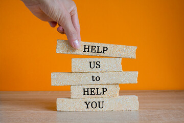 Concept words HELP US TO HELP YOU on brick blocks. Beautiful orange background. Businessman hand....