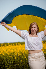Woman waving Ukraine flag in field