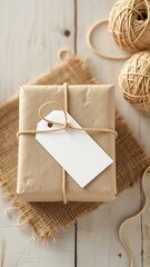 A beautifully wrapped present, resting on burlap, with a blank label, and string balls on a rustic wooden surface
