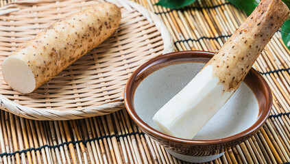 すり鉢に入った長芋と皮付きの長芋を竹ざるにのせた和の食材構成