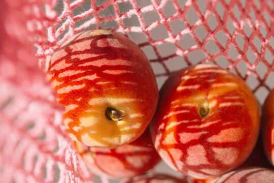 Fresh peaches in a pink string bag close up. Healthy food concept. Eco friendly theme. Summer backdrop - Powered by Adobe