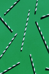 Minimal style composition made of paper straws on green background. Festive and party concept. Top...