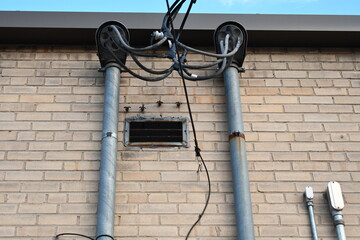 Two weatherheads on brick building. AC electrical hookup.