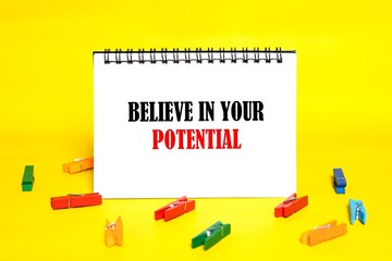 The word BELIEVE IN YOU POTENTIAL in the notebook. Business concept