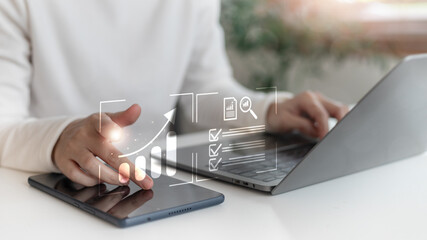 Businesswoman analyzing data and growth performance using a tablet and a laptop with a digital chart and analytics dashboard. Concept of digital marketing and business intelligence.