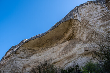 A mountain with a large grotto against the sky.