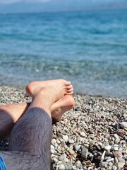 Relaxing Barefoot on a Pebble Beach by the Sea