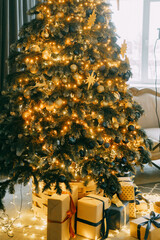 Decorated Christmas tree with golden moon and stars, festive ornament on artificial branches. Traditional holiday season celebration decoration.