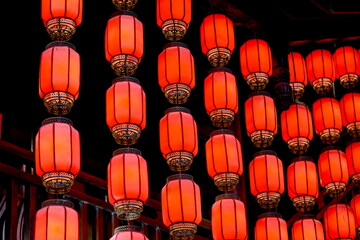 A beautiful row of vibrant red lanterns gracefully hanging from the ceiling