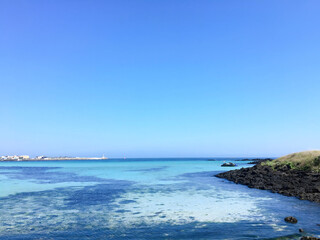 Clear Blue Sea and Sky with Rocky Coastline