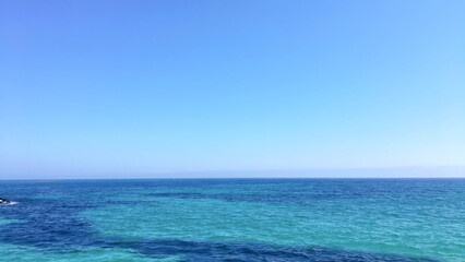Clear Blue Sea and Sky with Rocky Coastline