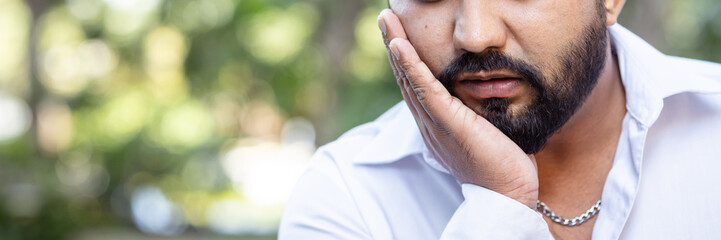 Young adult South asian, Indian man suffering from toothache, tooth decay, tooth sensitivity, teeth...