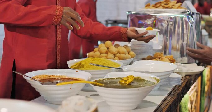 Indian caterers preparing delicious chat, panipuri, bhel, and patis at a festive event, showcasing vibrant flavors and traditional street food culture