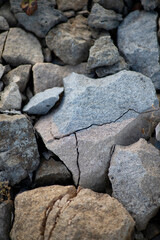 close-up shot of natural cracked stones, showing texture, shadows, and earthy tones. High quality photo